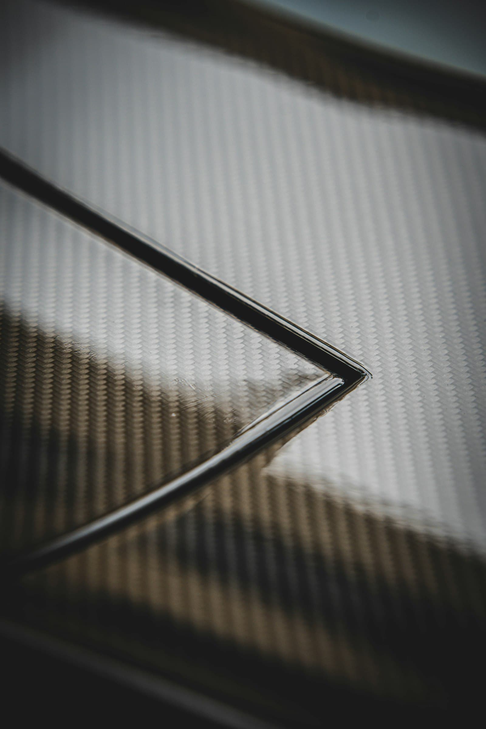 Macro detail of a woven carbon composite surface showing its raised texture