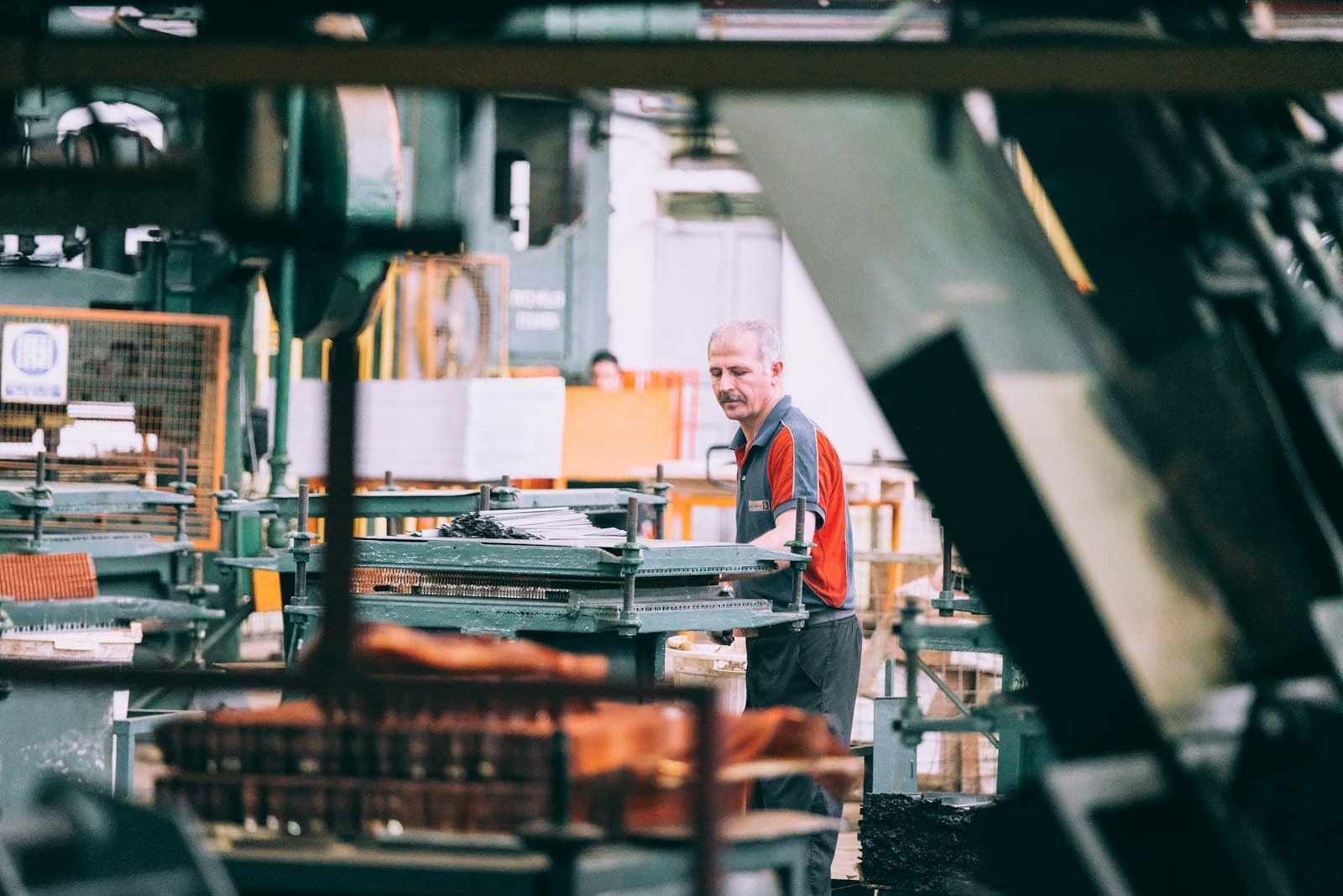 Worker operating production machinery on a factory floor