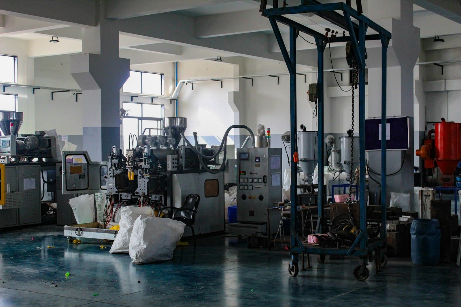 Material hoppers and processing machinery in a composites workshop